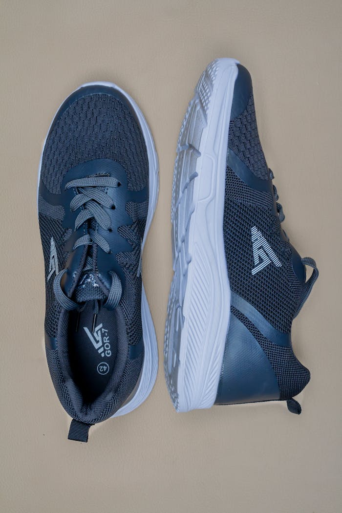 Close-up of blue athletic sneakers on a beige surface, highlighting style and design.